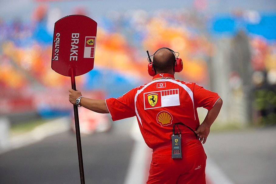 Ferrari's lollipop man awaiting his car in pit lane