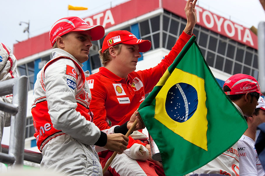 The two Finns Kovalainen and Raikkonen wave from the drivers parade truck