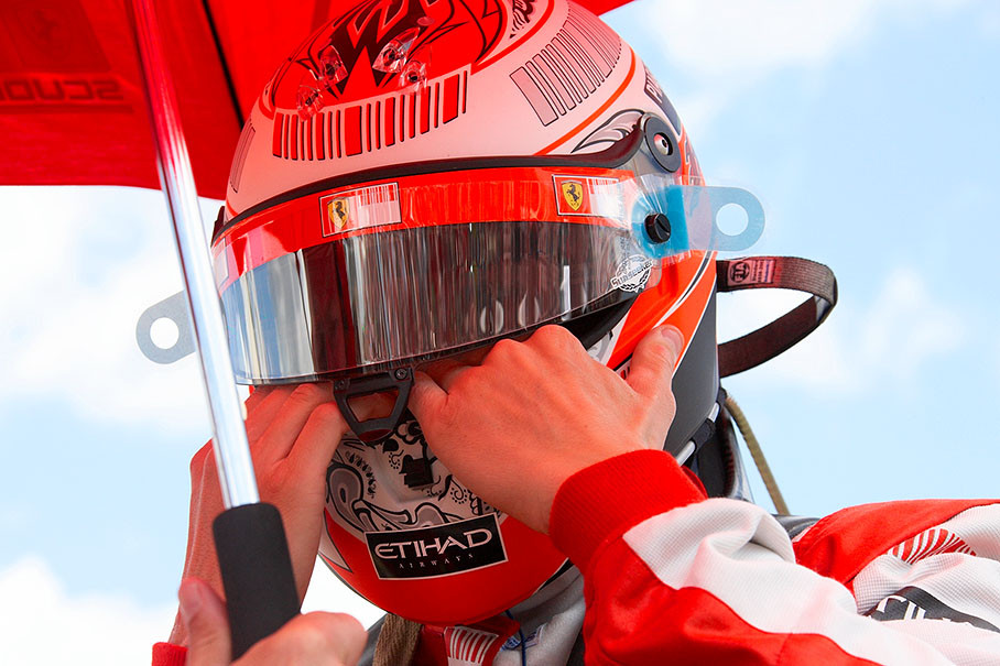 Kimi Raikkonen puts his helmet on