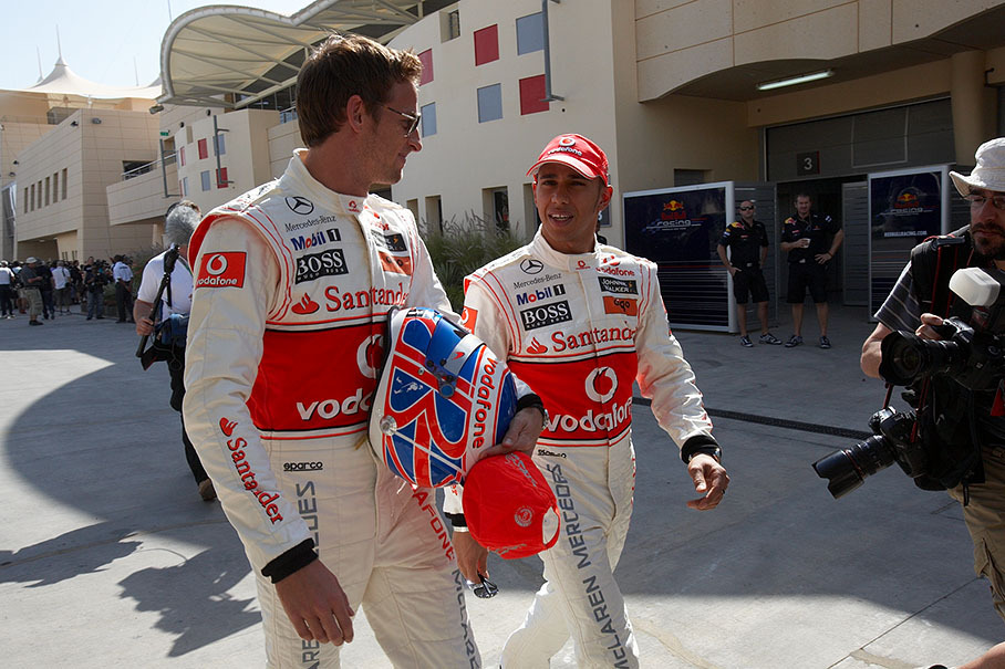 The two british McLaren drivers and World Champions Button and Hamilton walk through the paddock