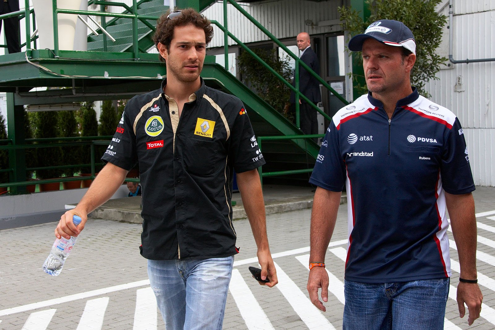Brazilian drivers Bruno Senna and Rubens Barrichello stroll through the paddock after the drivers briefing