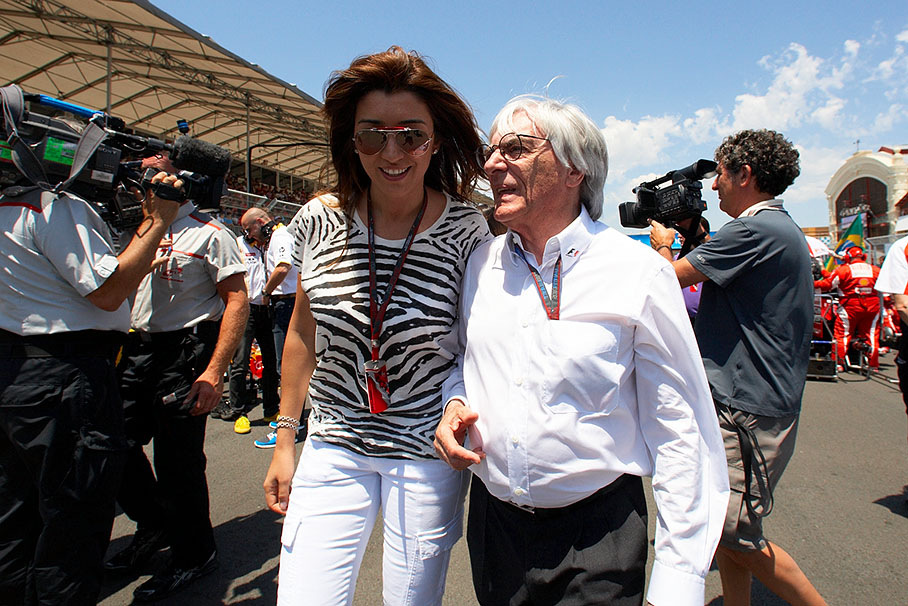 Bernie Ecclestone walks across the grid with his friend