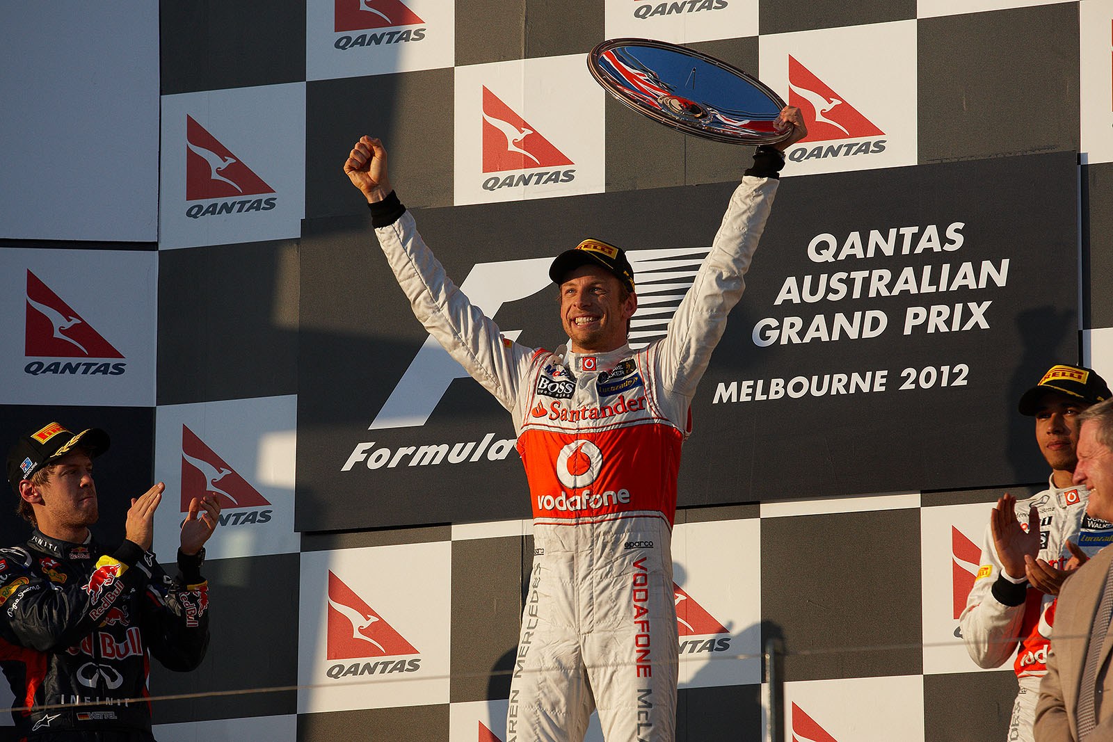 Race winner Jenson Button of McLaren celebrates on the podium