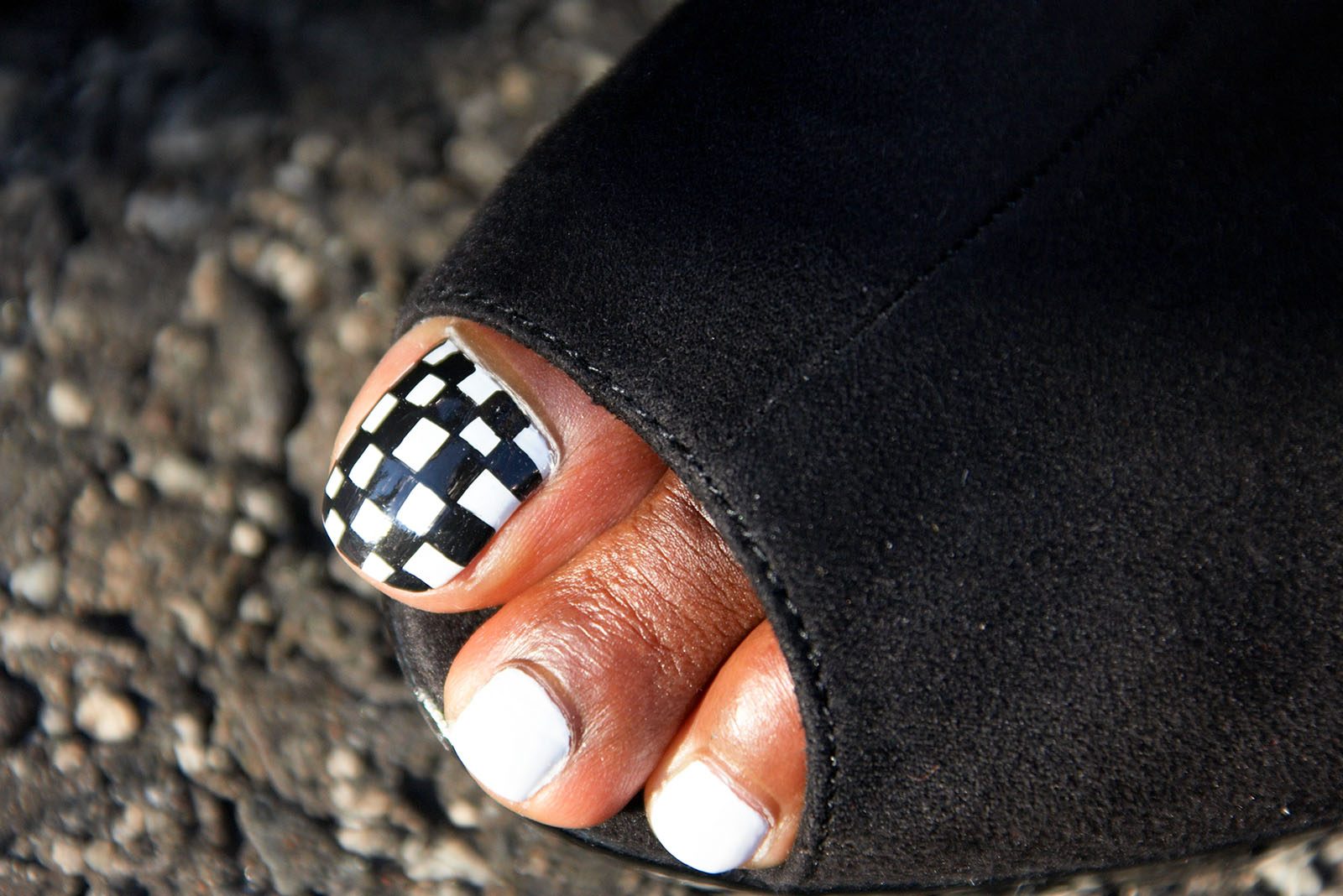 A chequered flag on a grid girl's toe