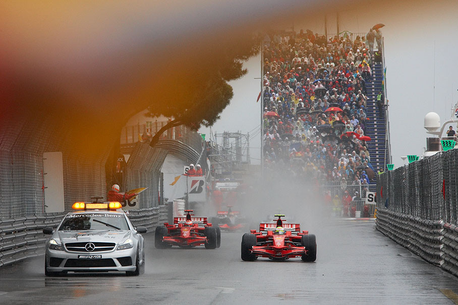 The safety car leads the two Ferraris to Tabac corner