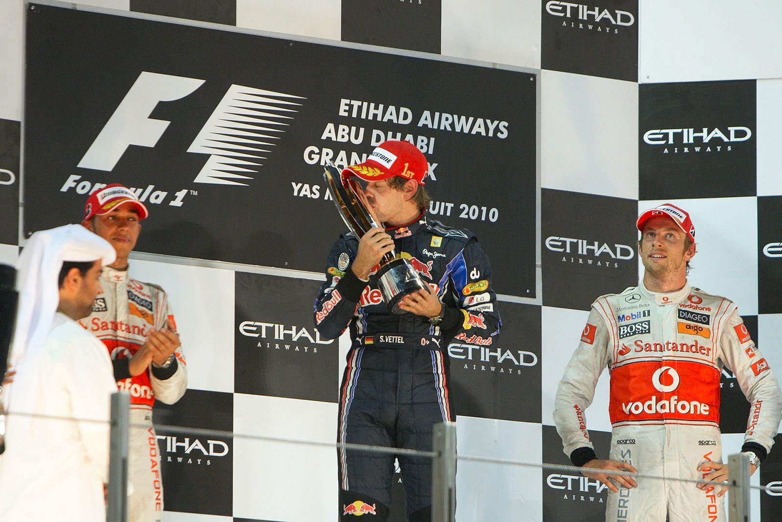 Race winner and youngest World Champion ever Sebastian Vettel kisses his trophy on the podium