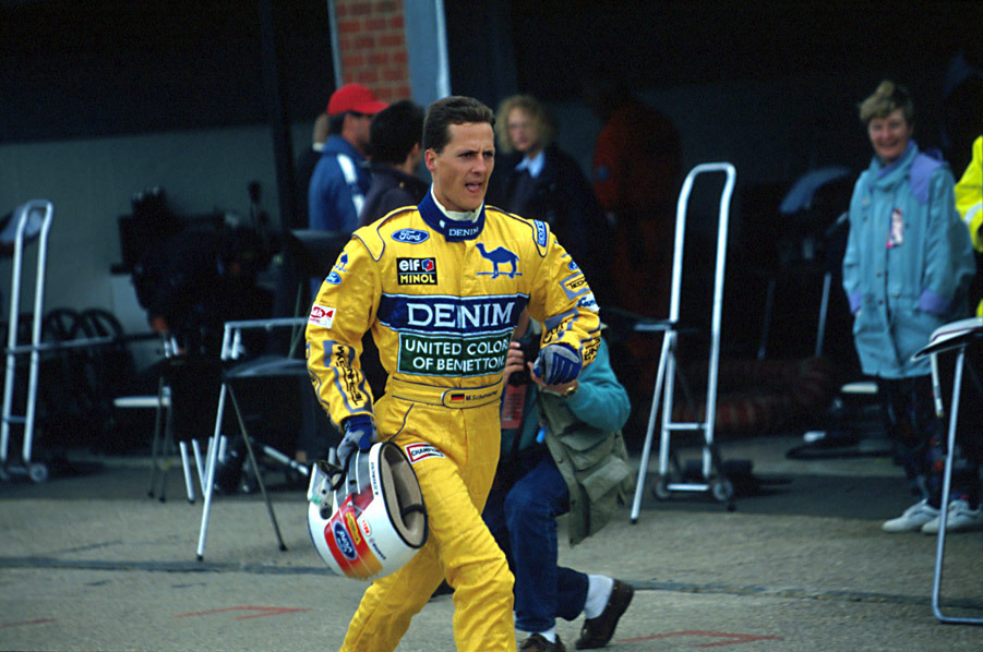 Michael Schumacher running through the pit lane with his helmet in his hand