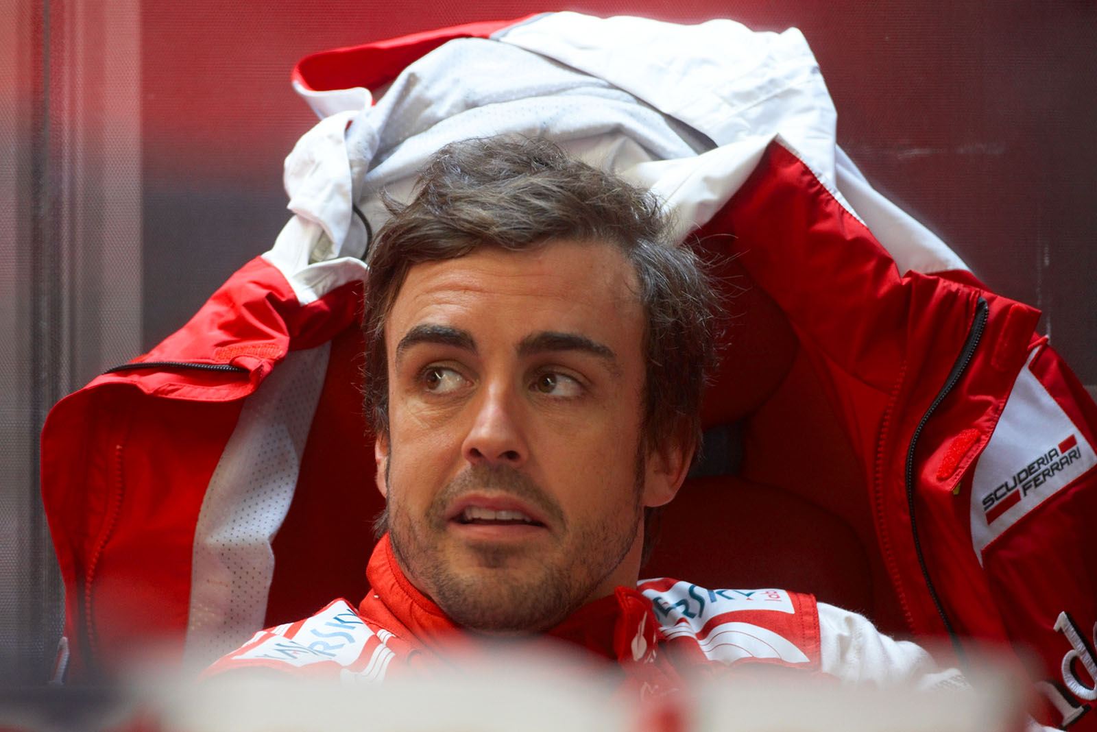 Ferrari's Fernando Alonso sits in the comfortable pits for a brake during a rainy session