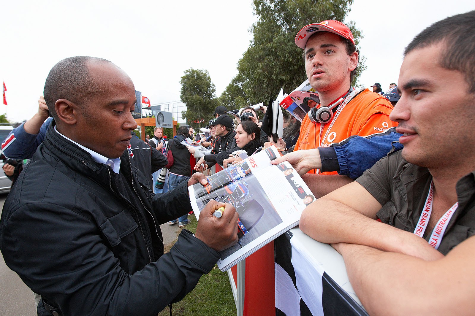Anthony Hamilton, father of World Champion Lewis Hamilton, signs as the new manager of Paul di Resta (here he puts an autograph on a photo of McLaren driver Button)