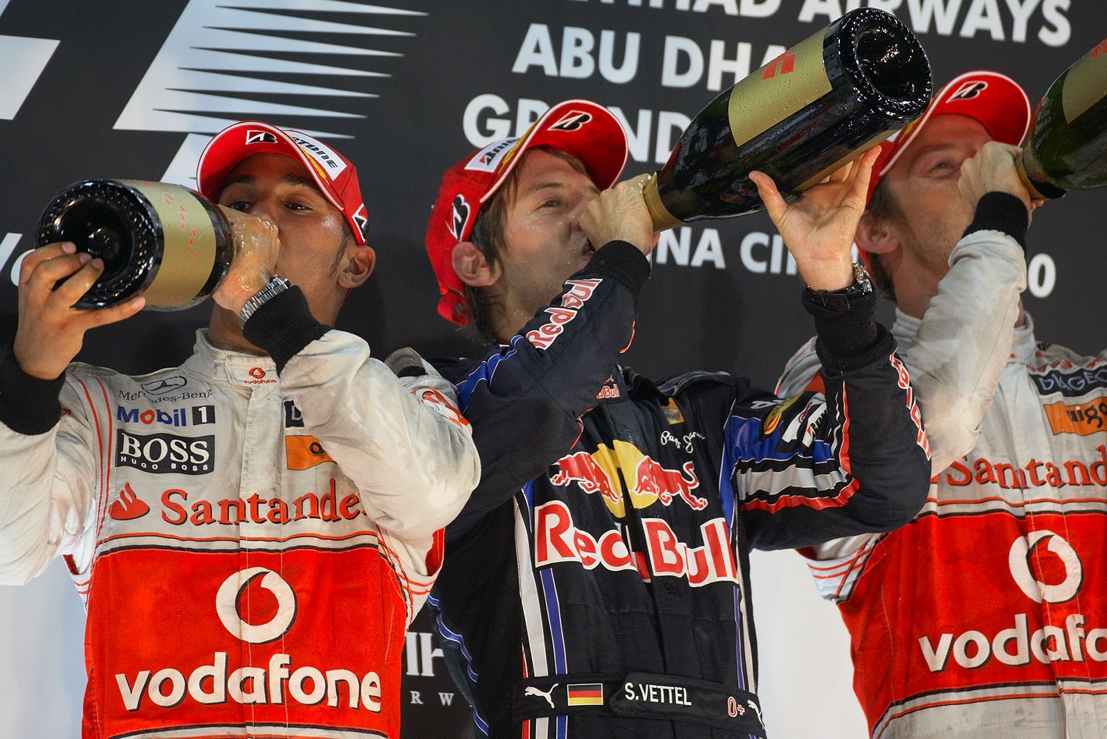 Youngest World Champion ever Sebastian Vettel celebrates on podium between McLaren's Hamilton and Button