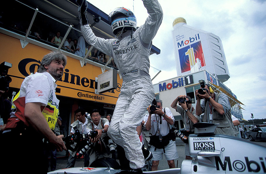 Mika Häkkinen jumps on his car after securing another 1-2 win for McLaren in front of David Coulthard and Jacques Villeneuve (Williams)