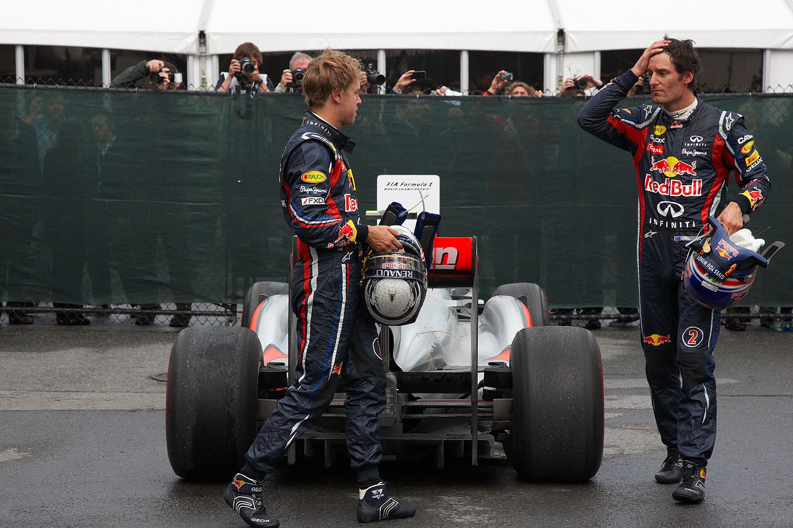 Red Bull team mates Sebastian Vettel and Mark Webber walk round Button's winning McLaren-Mercedes in parc ferme