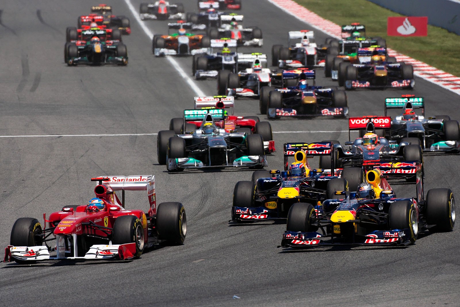 Alonso, followed by Vettel, negotiate the first corner after the start.
