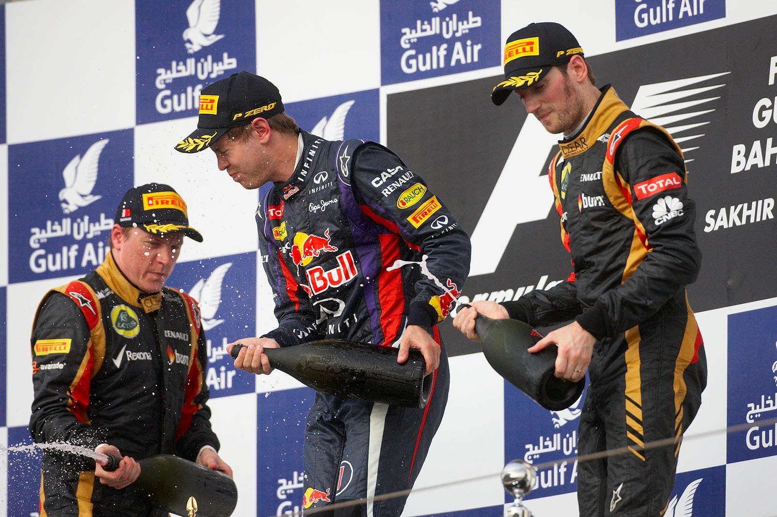 Race winner Sebastian Vettel of Red Bull Racing sprays sparkling rose water (instead of champagne) with the second and third placed Lotus race drivers Raikkonen and Grosjean
