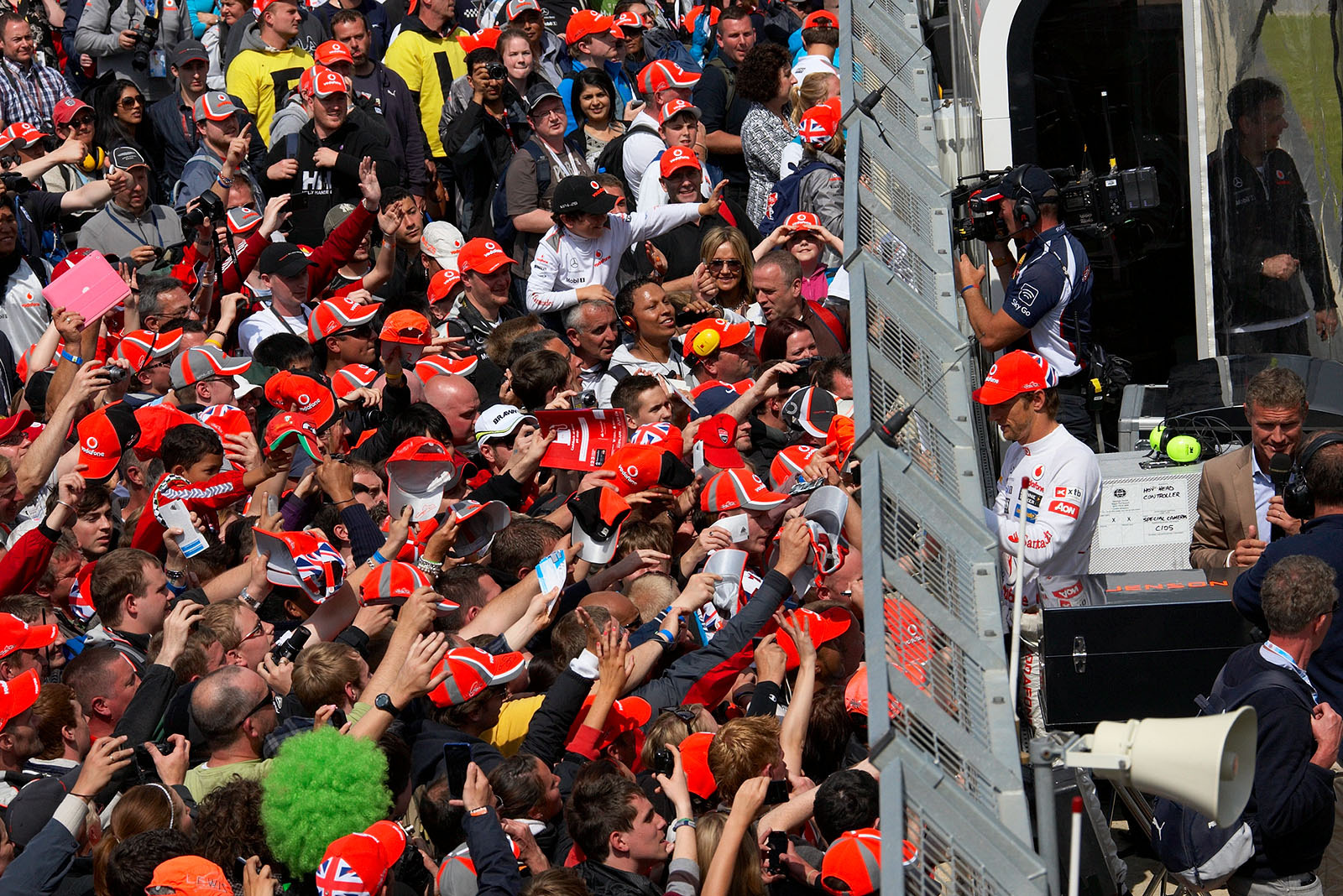 Race fans invade the track after the podium ceremony and Jenson Button gives autographs