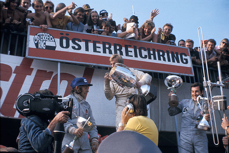 Race winner Ronnie Peterson celebrates on the podium after the Austrian GP 1973 with second placed Jackie Stewart and third Carlos Pace