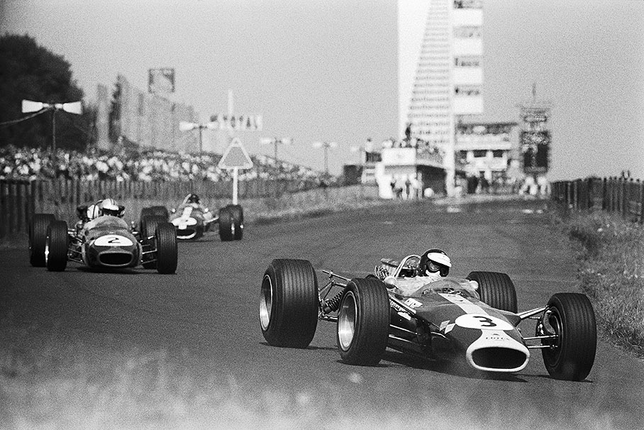 Jim Clark, Lotus 49, leads Denny Hulme’s BRM and Dan Gurney’s Eagle-Weslake at the end of the main straight. Clark later retires, Gurney leads and breakes down, leaving Hulme to win.
