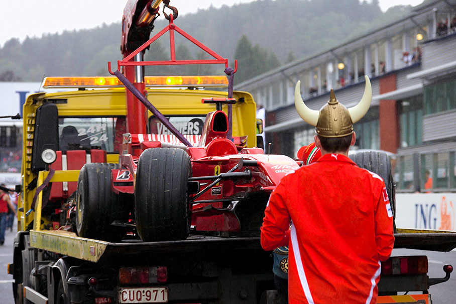 Kimi Raikkonen's damaged Ferrari is being brought to pits during podium ceremony