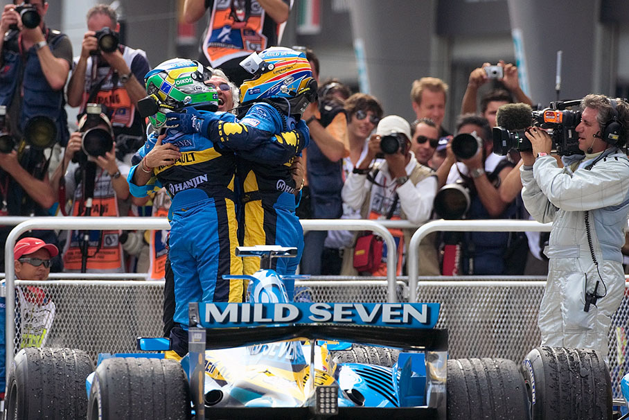 Giancarlo Fisichella and Fernando Alonso squeezing their godfather Flavio Briatore