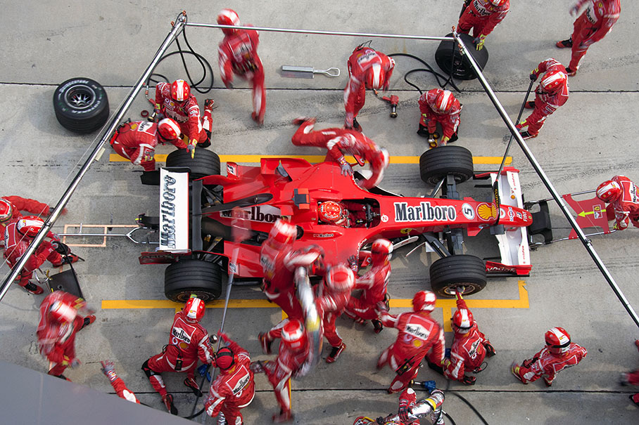 Michael Schumacher with a busy crew surrounding him