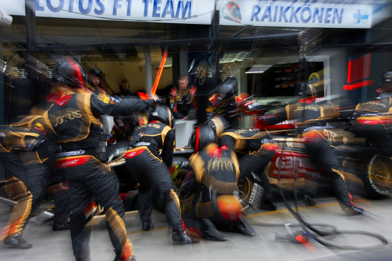 Soon race leader Kimi Raikkonen gets his wheels changed in Lotus pits