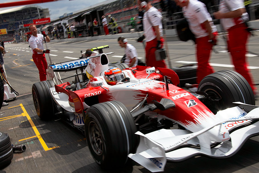 Timo Glock practices a pit stop with the Toyota pit crew