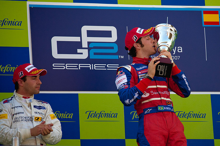 Timo Glock watchs Bruno Senna who kisses his first GP2 winner's trophy