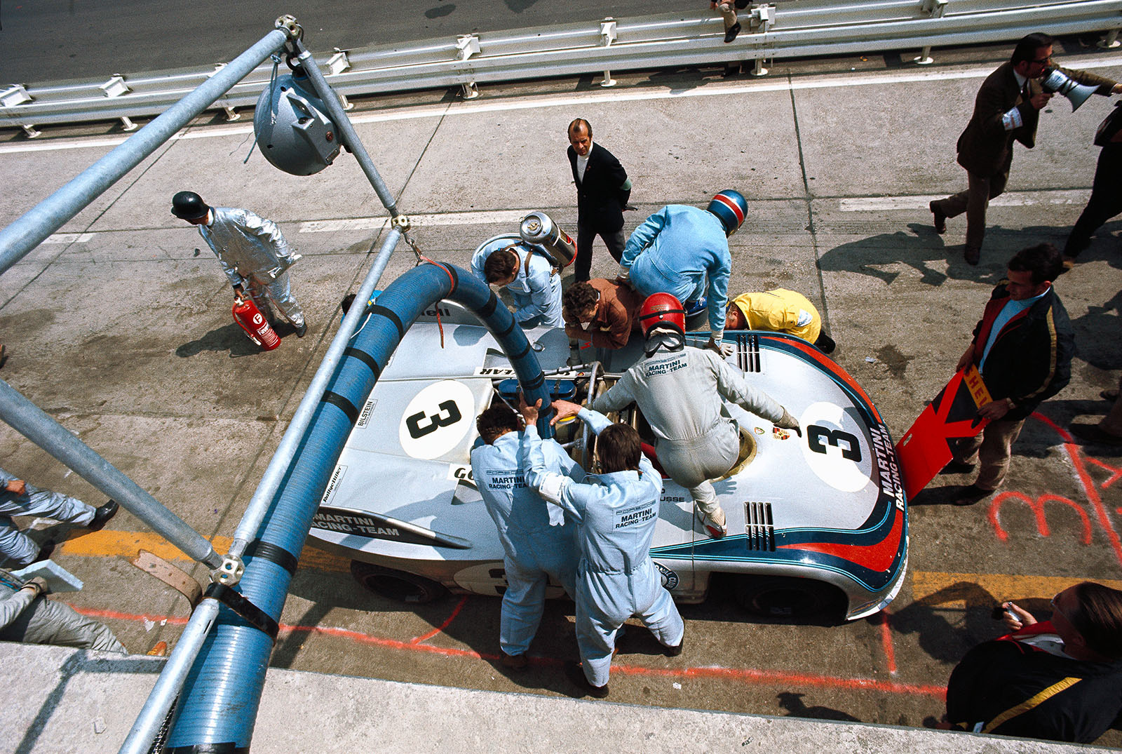 During a pit stop Vic Elford takes the winning Porsche 908/03 008 over from Gerard Larrousse