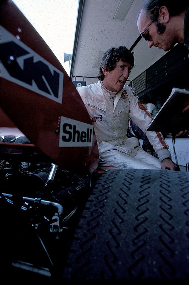 Jochen Rindt sits on his Lotus-Cosworth 72 whilst talking to Lotus team boss Colin Chapman