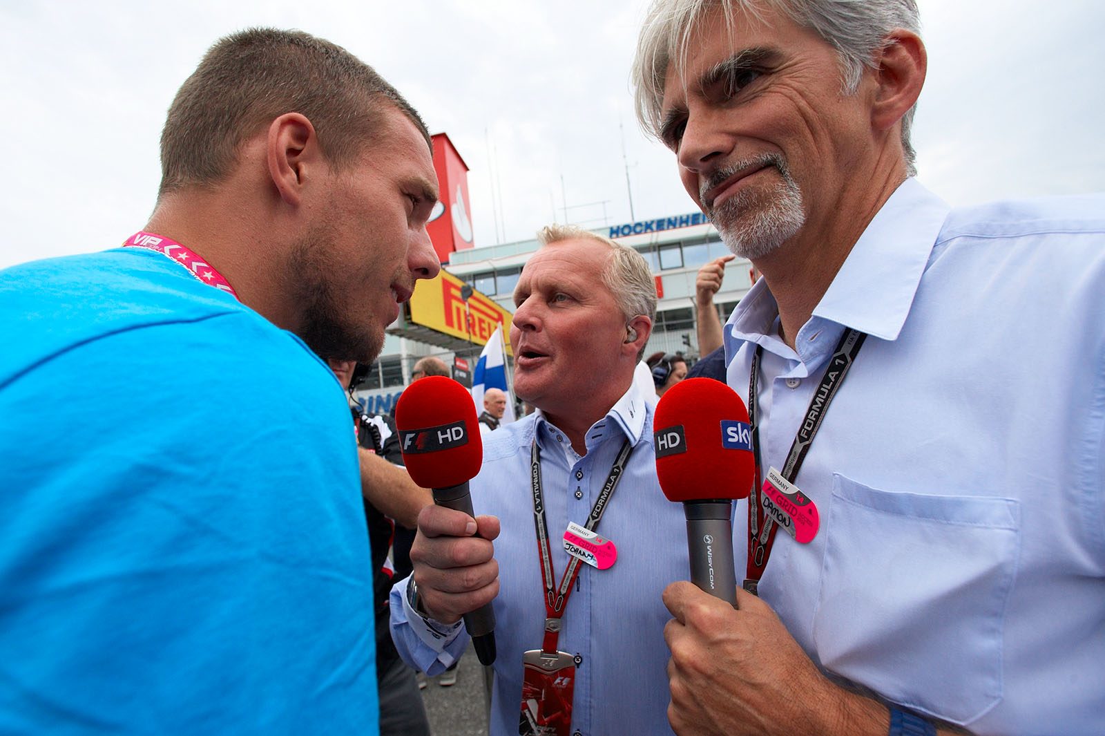 Lukas Podolski, German football player for Arsenal London, surrounded by former British F1 drivers Johnny Herbert and Damon Hill on the grid, Hockenheim, German Grand Prix, 2014