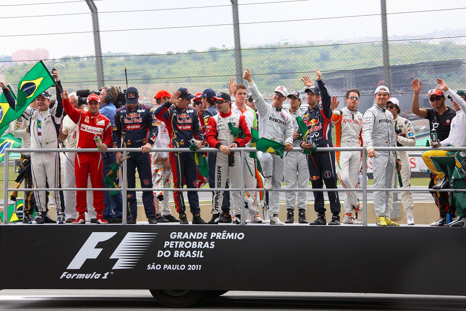 The F1 race drivers wave on their parade lap