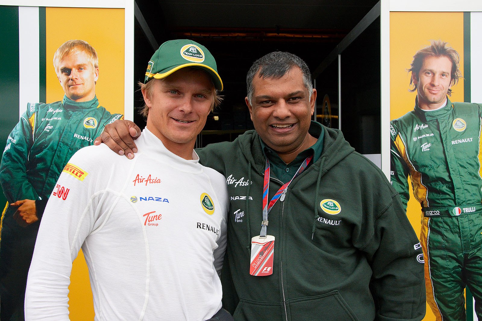 Heikki Kovalainen and Lotus Team boss Tony Fernandes pose in front of the pits