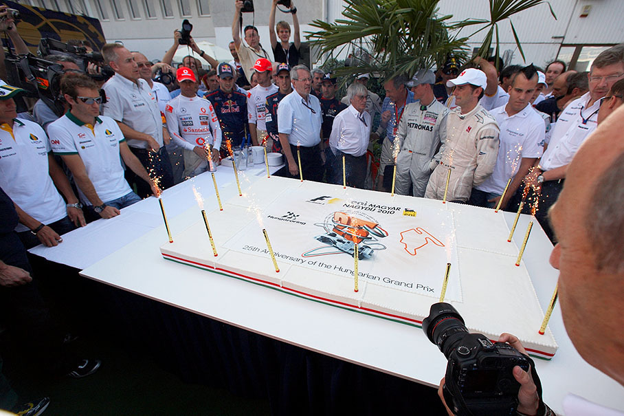 F1 drivers and honourables clustrer around the 1000-servings cream pie of Hungaroring's 25th anniversary