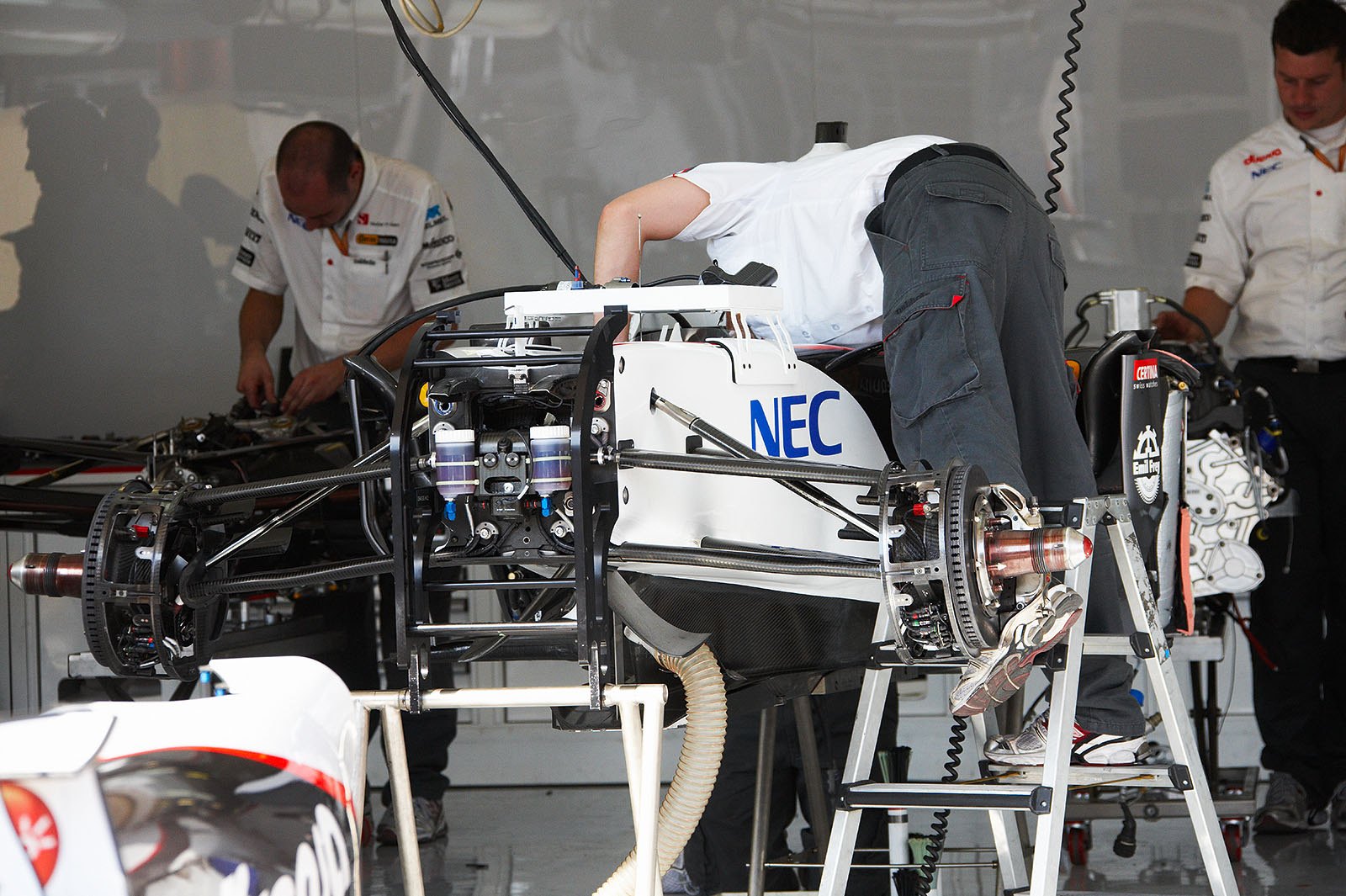 Busy mechanics work in Sauber pits on Thursday afternoon