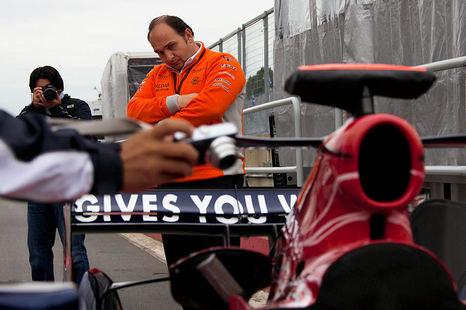 Spyker team boss Colin Kolles casts a covetous eye on a Toro Rosso's rear
