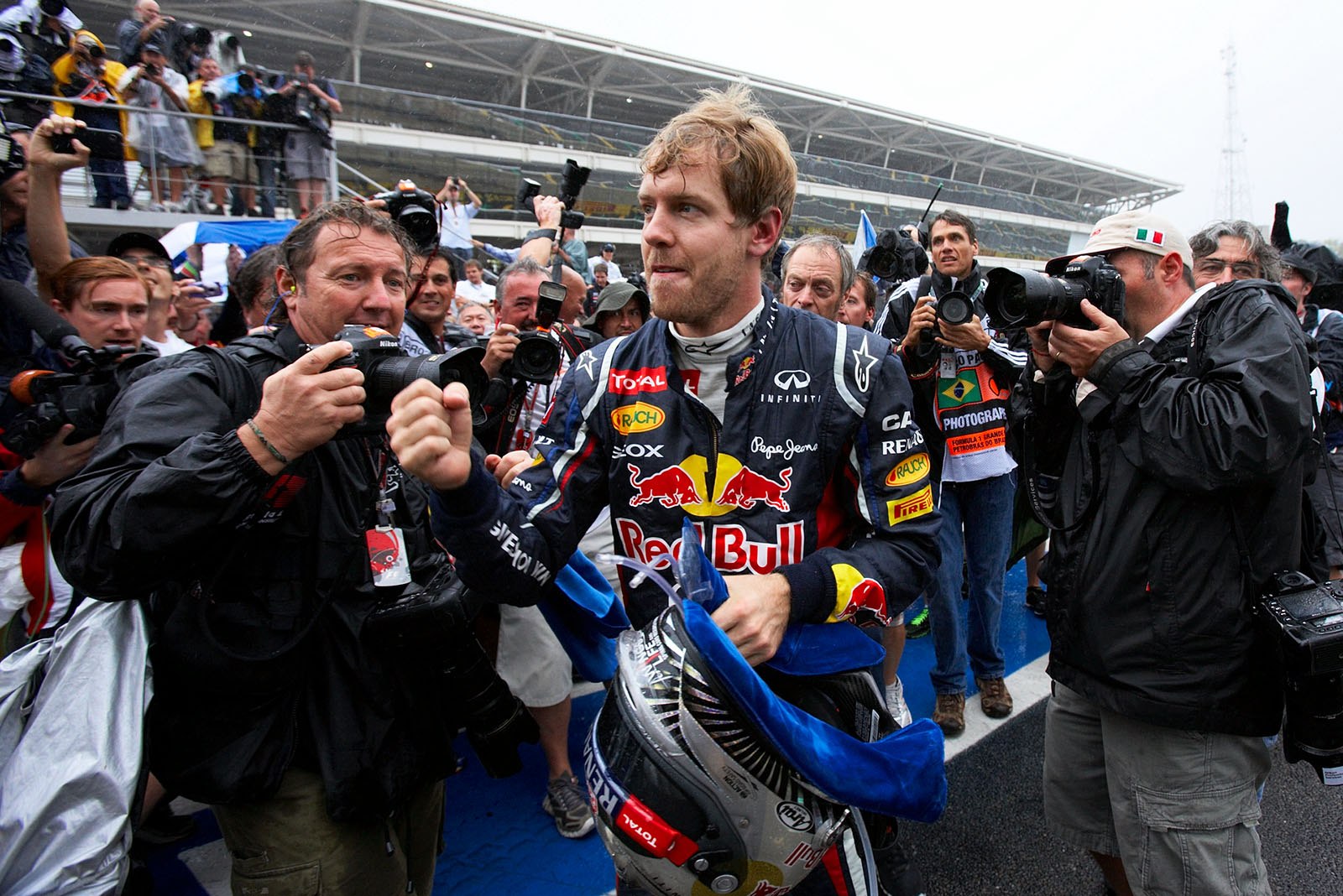 New triple World Champion Sebastian Vettel of Red Bull Racing is chased by the press after the race