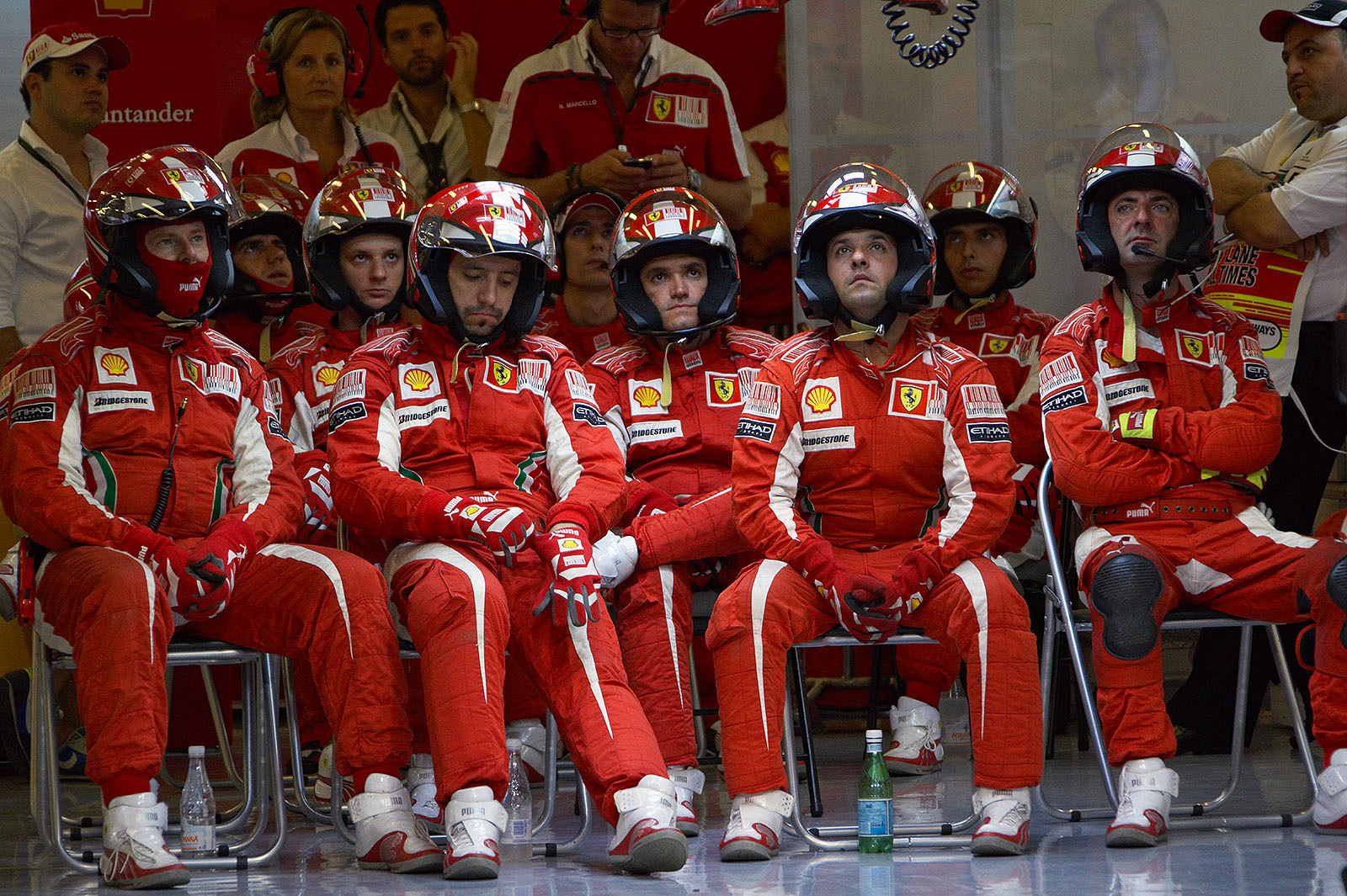 Ferrari mechanics wait in their pits