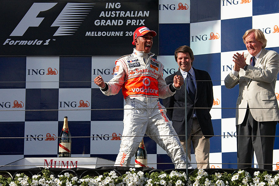 Race winner Lewis Hamilton celebrates on podium.