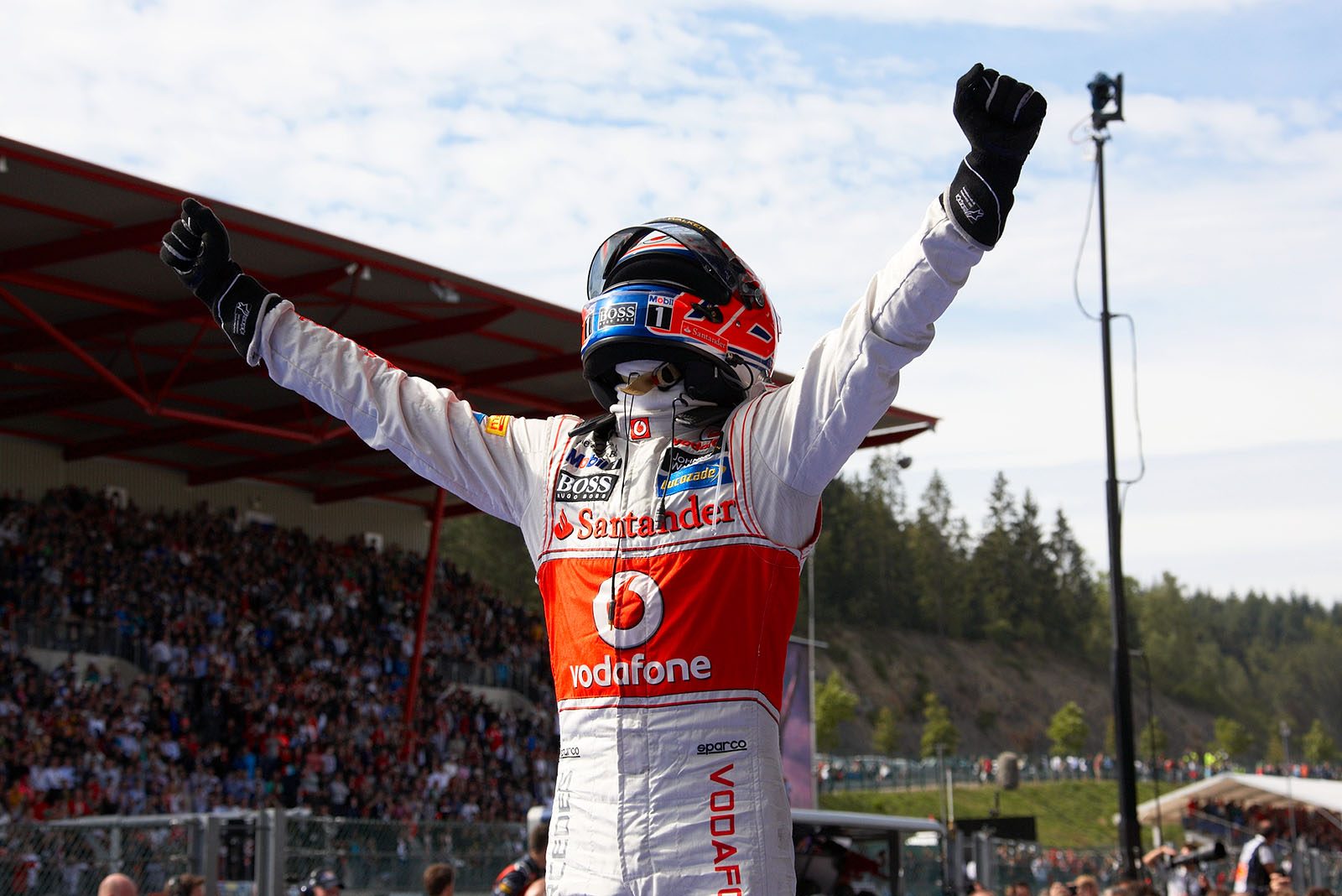 Race winner Jenson Button of McLaren Mercedes celebrates on his race car in parc ferme