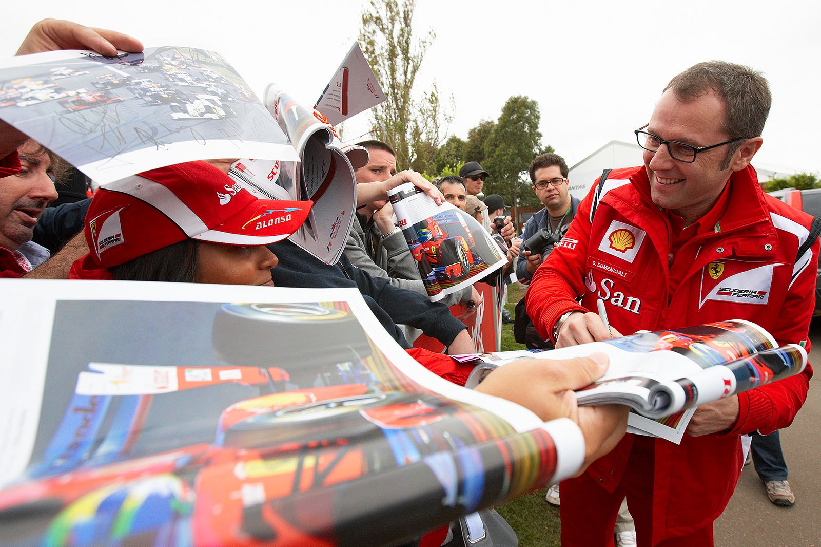 Ferrari team boss Stefano Domenicali chats with his fans as he arrives at the paddock