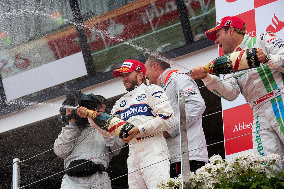 Champagne showers down the podium from celebrating Heidfeld and Barrichello