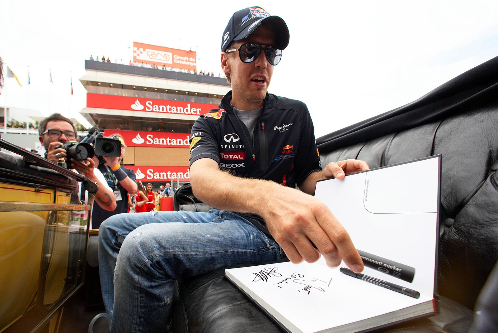 Red Bull's Sebastian Vettel writes into a guest book