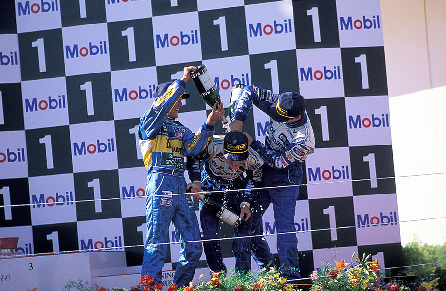 Race winner David Coulthard being showered with champagne by Williams teammate and third placed Damon Hill and Benetton driver Michael Schumacher who gained second place