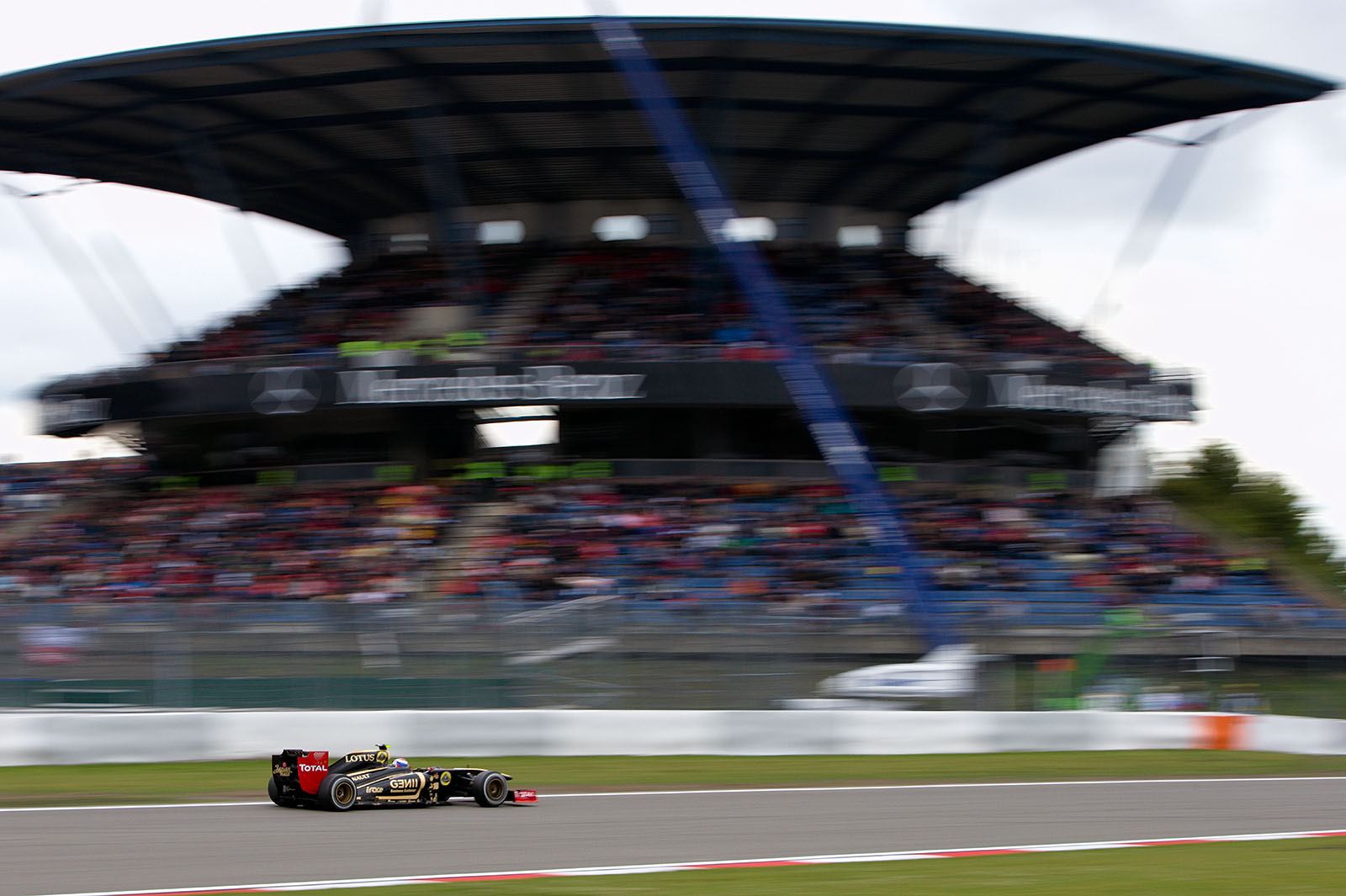 Vitaly Petrov of Lotus Renault GP passes the Mercedes grandstand