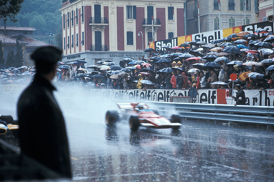 Spectators under umbrellas watch the qualification in the rain