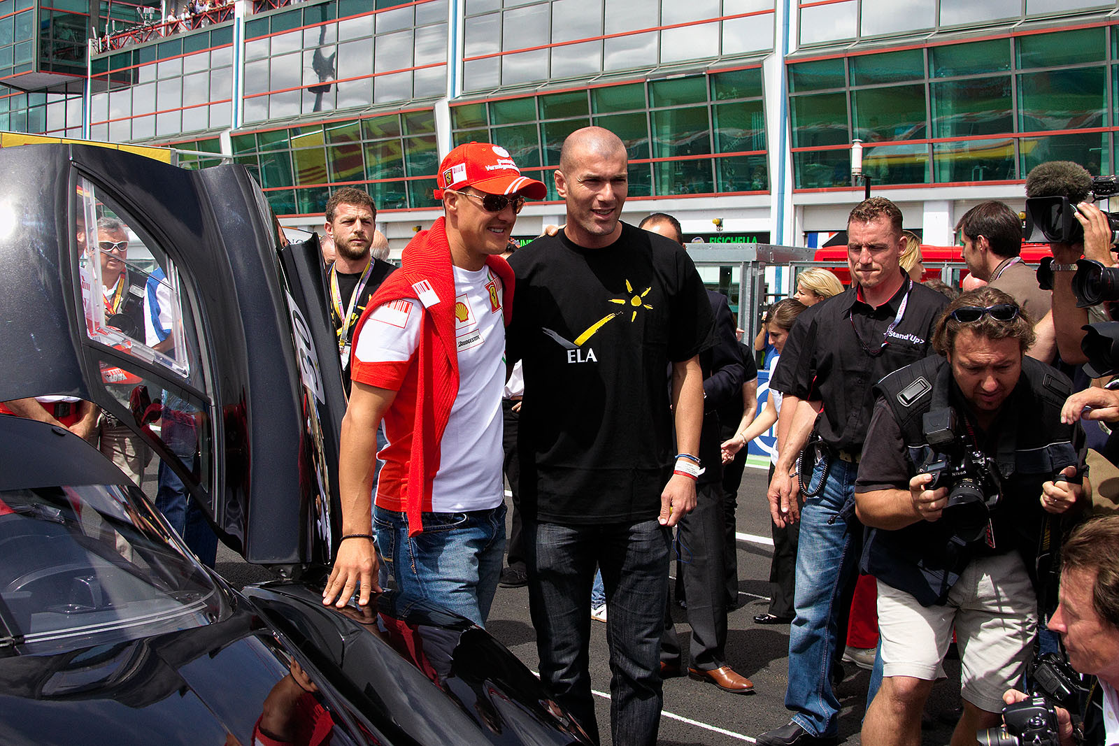 Memorable soccer star Zinedine Zidane and Michael Schumacher pose besides a special Ferrari Enzo