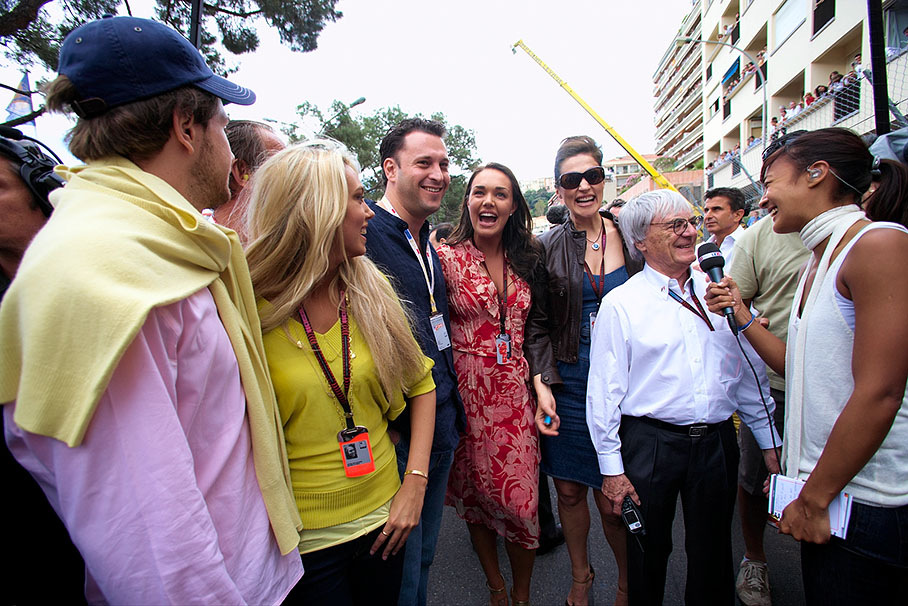 Bernie Ecclestone gives an interview on the grid, his family behind him