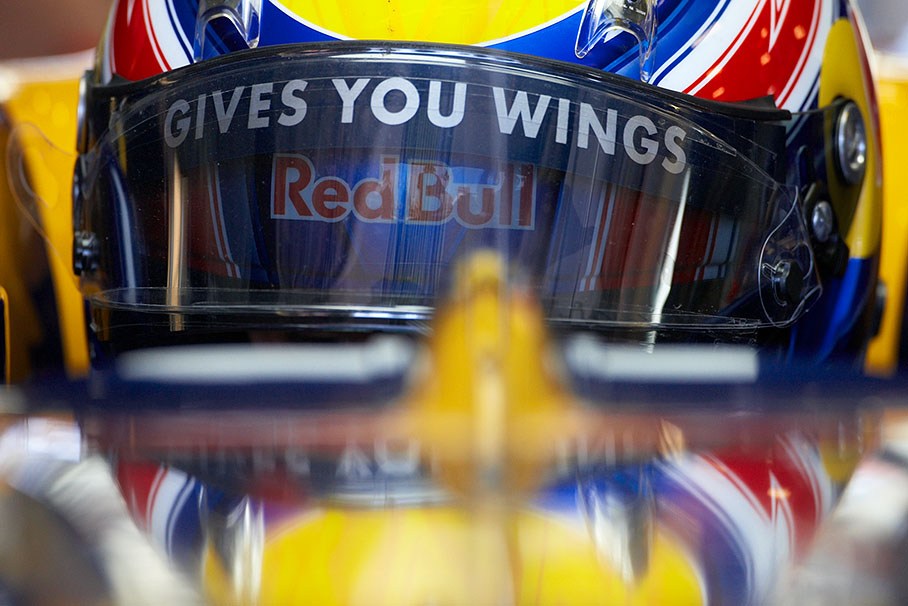 The helmet of Mark Webber reflects at a Red Bull Racing cars surface