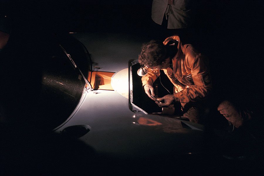 A mechanic fixes the victorious Ford GT40 during a pit stop at night