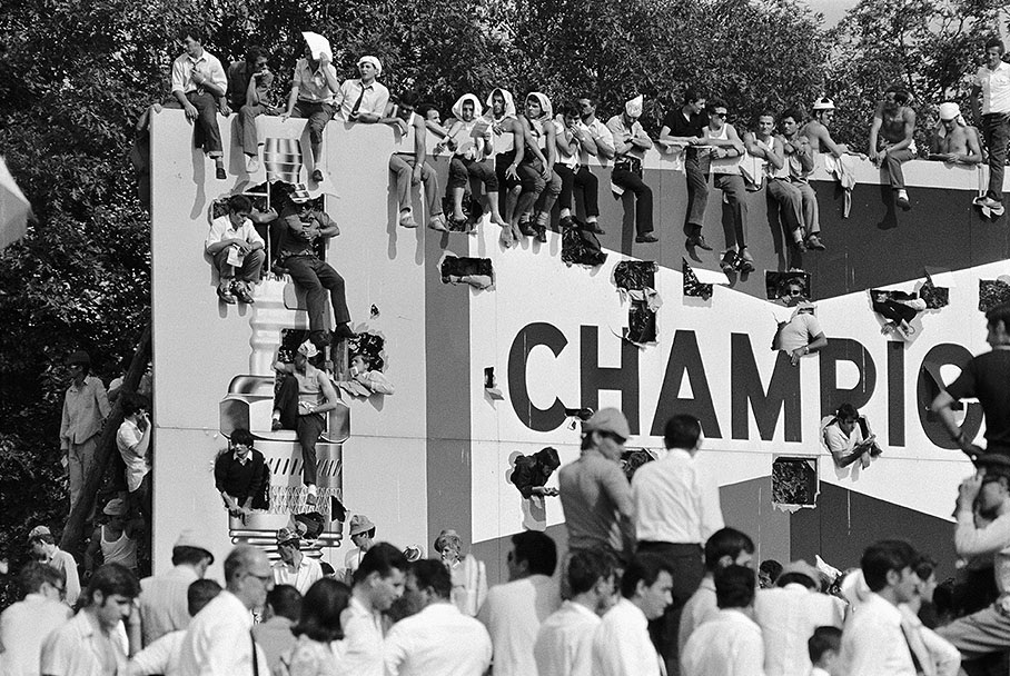 Italian fans occupy Agip's advertising billboard as a temporary grandstand, Italian GP Monza 1968